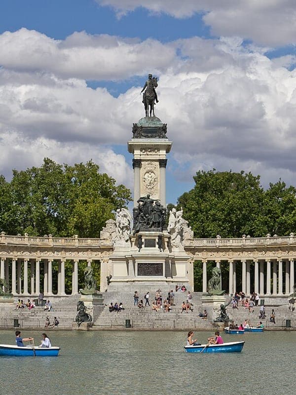 Rowing boats on the Retiro Park lake in Madrid, in front of the Alfonso XII monument
