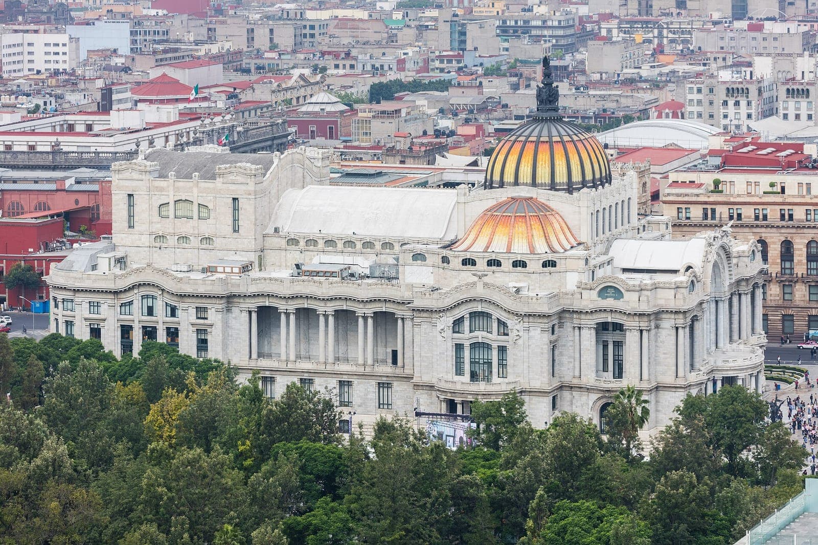 El Palacio de Bellas Artes, con sus cúpulas naranjas, entre los árboles de la Alameda en Ciudad de México